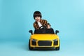 Little child driving yellow toy car on light blue background Royalty Free Stock Photo