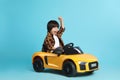 Little child driving yellow toy car on light blue background Royalty Free Stock Photo