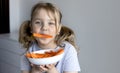 Little child eating carrots empty space background. Healthy nutrition concept. Kid girl eats vegetables Royalty Free Stock Photo