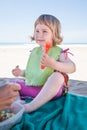 Little child eating with fork in hand at beach Royalty Free Stock Photo