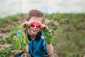 Little child eating fresh harvested ripe radish in the garden