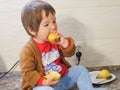 Little child eats a pear. child boy eating fruits at a high stoic. in the kitchen Royalty Free Stock Photo