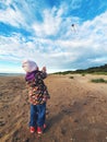 Little child flying a kite in the sky on the beach Royalty Free Stock Photo