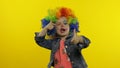 Little child girl clown in colorful wig making silly faces. Having fun, smiling, dancing. Halloween Royalty Free Stock Photo