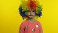 Little child girl clown in colorful wig making silly faces, having fun, smiling, dancing. Halloween Royalty Free Stock Photo