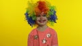 Little child girl clown in colorful wig making silly faces, having fun, smiling, dancing. Halloween Royalty Free Stock Photo