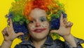 Little child girl clown in colorful wig tells something interesting. Having fun, smiling. Halloween Royalty Free Stock Photo