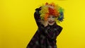 Little child girl clown in rainbow wig making silly faces. Having fun, smiling, dancing. Halloween Royalty Free Stock Photo