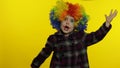 Little child girl clown in rainbow wig making silly faces. Having fun, smiling, dancing. Halloween Royalty Free Stock Photo