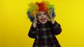 Little child girl clown in rainbow wig making silly faces. Having fun, smiling, dancing. Halloween Royalty Free Stock Photo