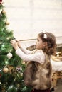 Little child girl decorating Christmas tree with balls at home, indoors. Close up. Christmas concept Royalty Free Stock Photo