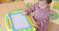 little child girl drawing on magnetic erasable board