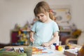 Little child girl draws And watches a drawing lesson online on a tablet in home. Royalty Free Stock Photo