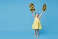 Little child girl is holding foil balloons in the form of numbers 20 twenty percent. The concept of discounts,