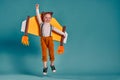 Little child girl with jet cardboard wings is playing and dreaming of becoming a pilot Royalty Free Stock Photo