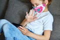 Little child girl in mask at home talk video with tablet meeting, online call friend