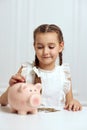 Little child girl with piggy bank at home Royalty Free Stock Photo