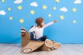 Little child girl in a pilot`s costume is playing and dreaming of flying over the clouds. Royalty Free Stock Photo