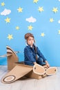 Little child girl in a pilot`s costume is playing and dreaming of flying over the clouds. Royalty Free Stock Photo