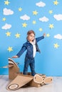 Little child girl in a pilot`s costume is playing and dreaming of flying over the clouds. Royalty Free Stock Photo