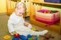 Little child girl playing in kindergarten in Montessori preschool Class. Adorable kid in nursery room.