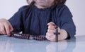 Little child girl praying and holding a wooden rosary as symbol of belief and faith in Jesus Christ and eternal life