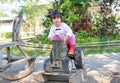 Little child girl riding on an old wooden toy tractor in the garden Royalty Free Stock Photo