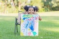 Little child girl shows her painting work. Cute kid show painting work in the garden Royalty Free Stock Photo