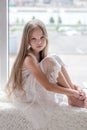 Little girl sits alone front of the window Royalty Free Stock Photo