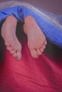 Little child girl sleeping in bed at home. Close up feet under the blanket on her bed on bedroom Royalty Free Stock Photo