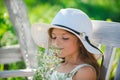 Little child girl is smelling flowers on green backyard. Adorable kid on a summer meadow and smelling flowers. Summer Royalty Free Stock Photo