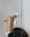 Little child girl try to open locked door, Little child hand on the door handle