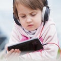 Little child girl using mobile phone watching online e-learning video to studying english Royalty Free Stock Photo