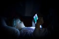 Little child girl using tablet technology in bed by night at home. Serious or toughtful kid daughter in bedroom watching