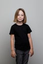 Little child girl wearing black t-shirt standing on white background. Happy Kid portrait Royalty Free Stock Photo
