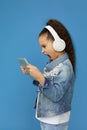 little child girl in white headphones holding digital tablet Royalty Free Stock Photo