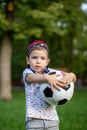 Little boy hugs a soccer ball and plays soccer in the summer in the park on the nature. Royalty Free Stock Photo