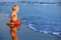 Little child has a fun on black sand sunset sea beach Royalty Free Stock Photo