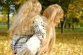 little child is having fun with her mother in city park, happy family life, kid girl on her back mom laughs, childish Royalty Free Stock Photo