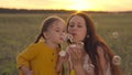 little child with her mother blowing soap bubbles at sunset, girl daughter with mom play fun outdoors together, happy Royalty Free Stock Photo