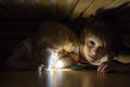 Little child, hiding under the bed, hugging teddy bear and holding flashlight Royalty Free Stock Photo