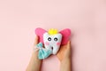 Little child holding felt tooth fairy toy in his hands on pink background. Easy and funny kids crafts, DIY, Happy Tooth Fairy Royalty Free Stock Photo