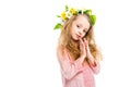 Little child holding handbreadths together and wearing wreath band from flowers