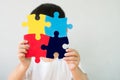 A little child holding a puzzle symbol of Public awareness for autism spectrum disorder.