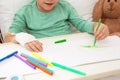 Little child with infusion drip drawing in hospital bed