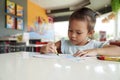 Little child intend coloring with crayons in the classroom