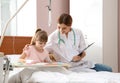 Little child with intravenous drip drawing in hospital bed Royalty Free Stock Photo