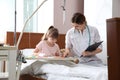 Little child with intravenous drip drawing in hospital bed Royalty Free Stock Photo