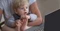 Little child looking excited and surprised at something on a laptop computer monitor in motherÃ¢â¬â¢s lap. Royalty Free Stock Photo