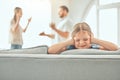 Little child looking stressed, covering her ears while her parents fight in the background. Two parents shouting about